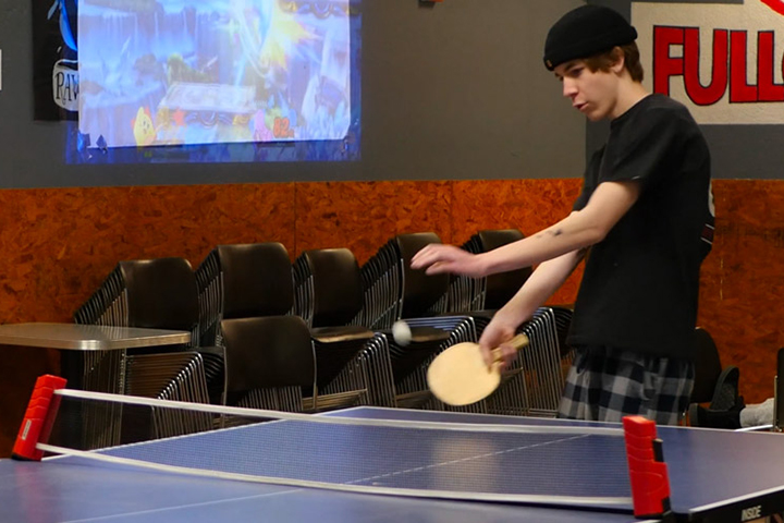 A teen playing pong at the Full Circle sobriety program.