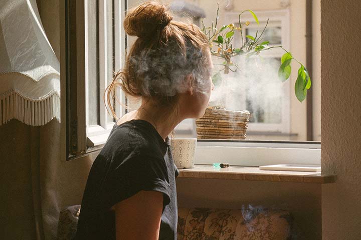 A teenage girl using marijuana in her bedroom.