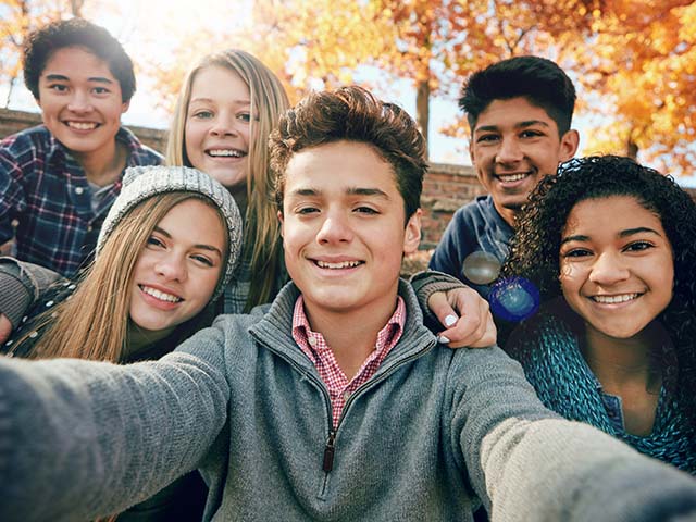 A group of young sober teens taking a selfie.