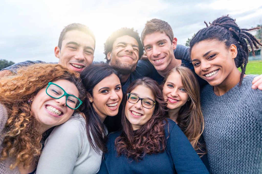 Young adults hugging and supporting each other at a sober event.