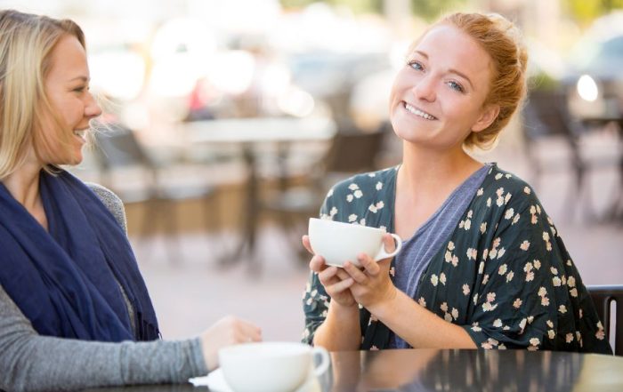 Two girlfriends in recovery sharing experience.