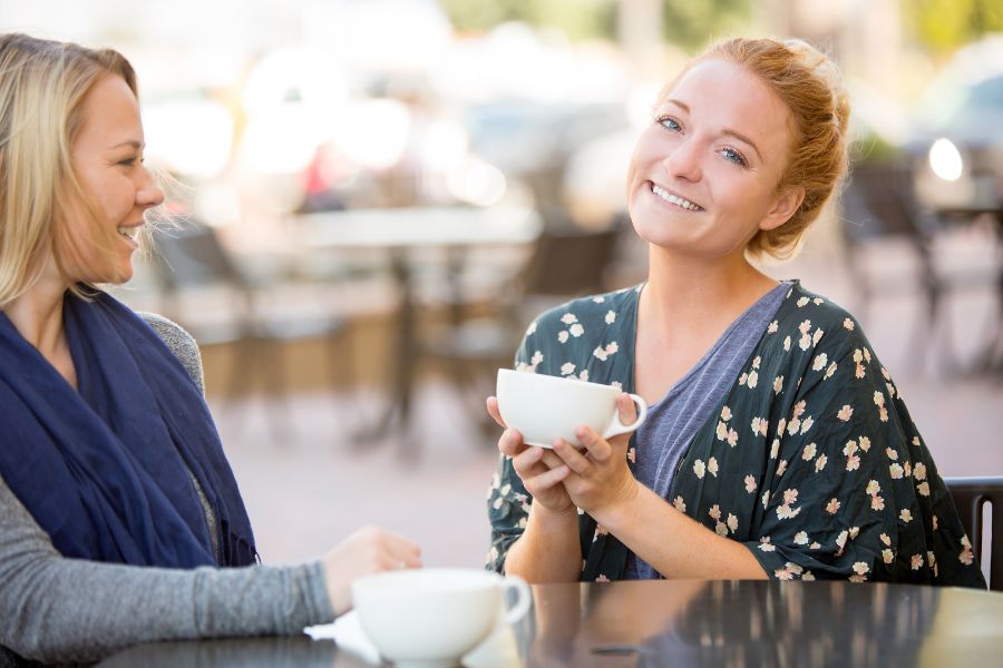 Two girlfriends in recovery sharing experience.